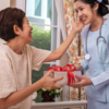 A nurse receives a box of chocolates from a patient as a gesture of gratitude in a hospital setting