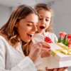 A mother and daughter joyfully opening a gift box together, sharing a moment of excitement and surprise