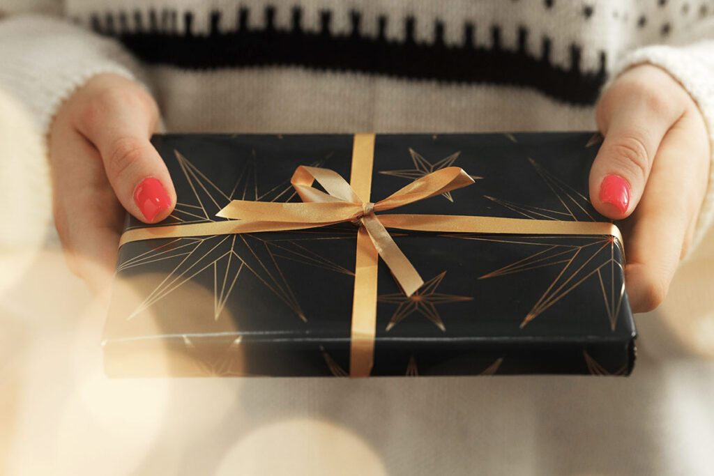 New year holiday business gift wrapped in black paper and tied with a bow.
